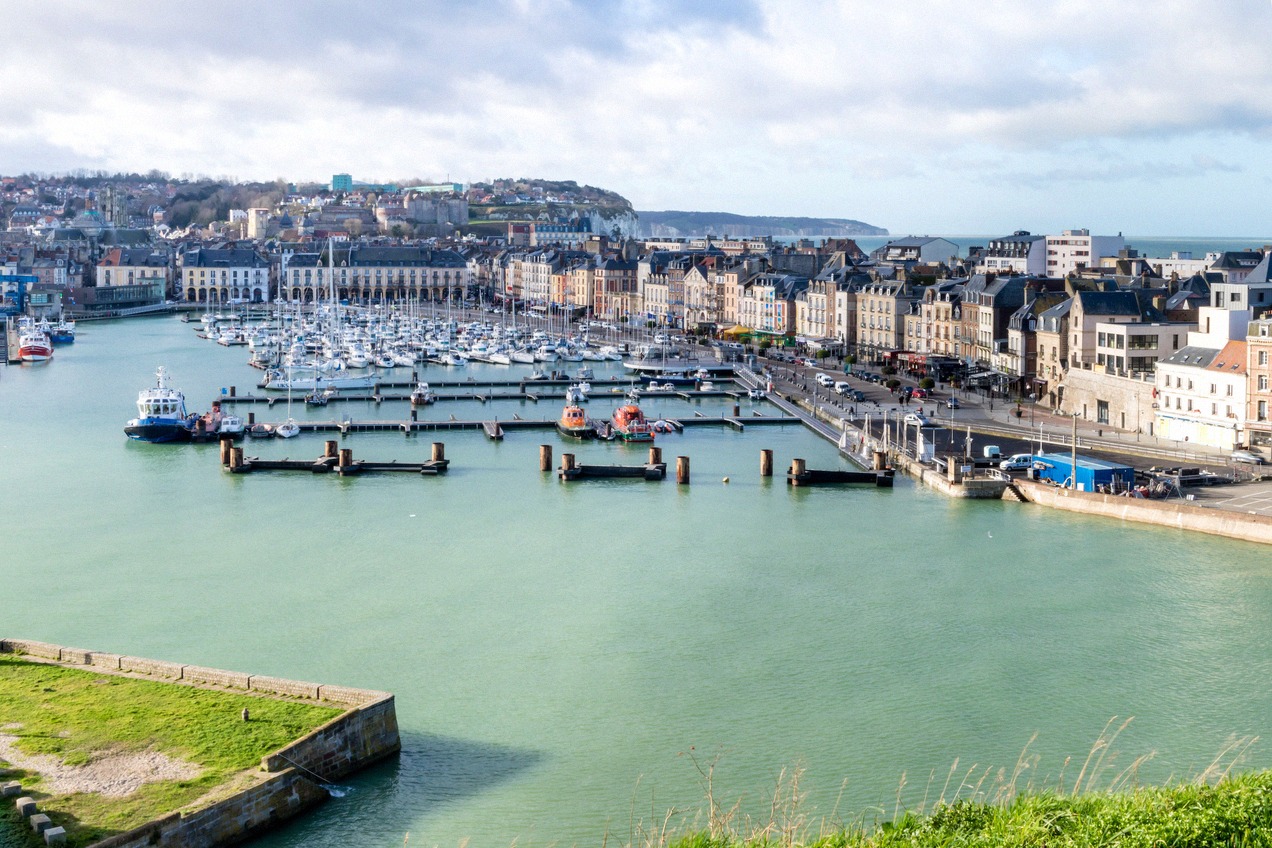 Boats moored in the harbour basin of Dieppe with the town rising behind