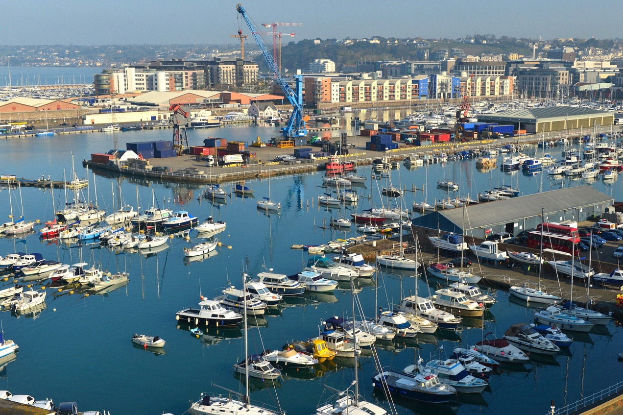 The harbour of St Helier on Jersey with moored boats and the town behind